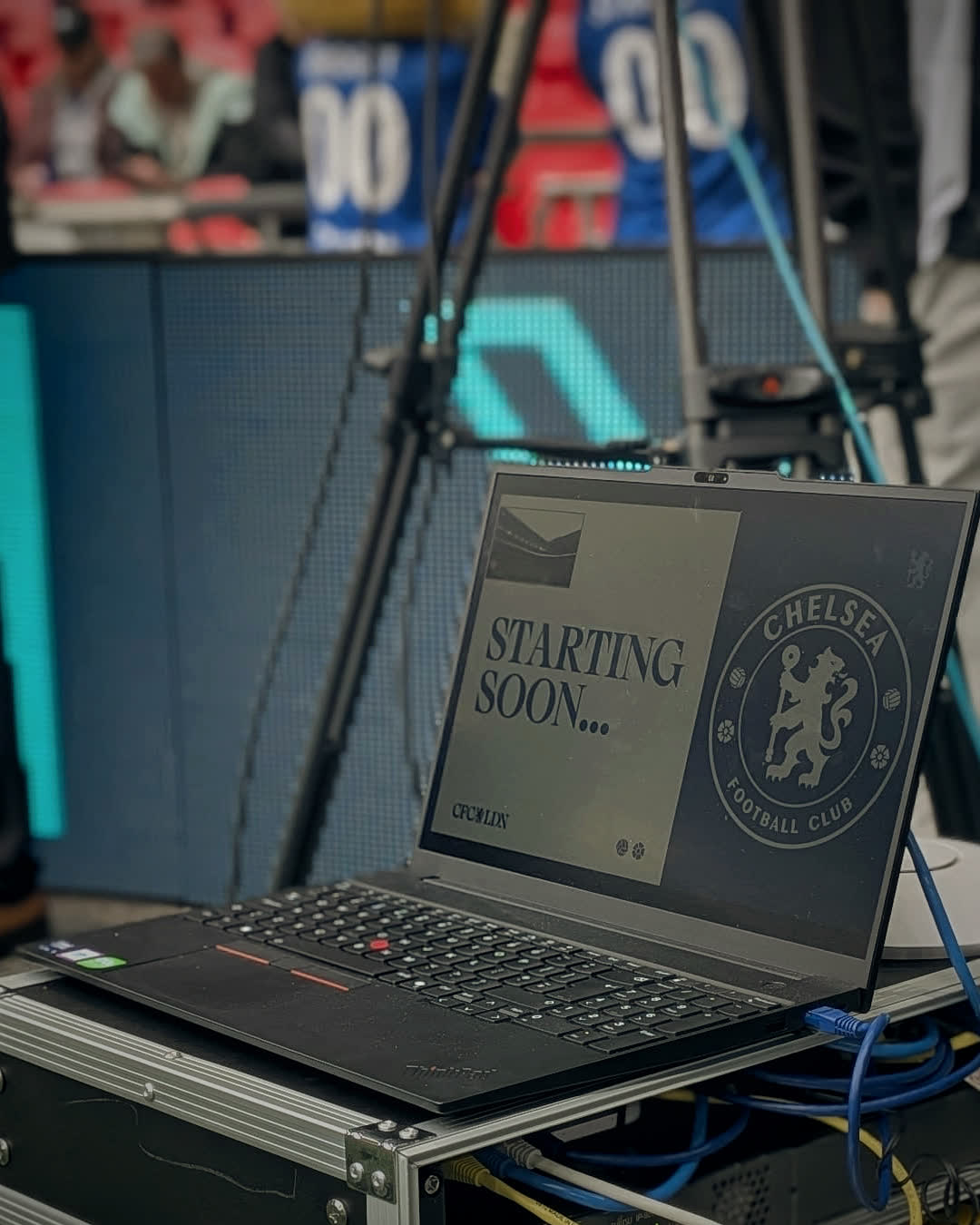 A laptop on a flight case of our network kit, pitchside at Wembley, showing a Chelsea ‘Starting soon’ slide.